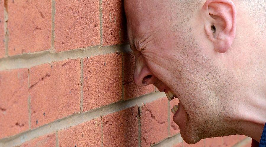 Man hitting head on brick wall